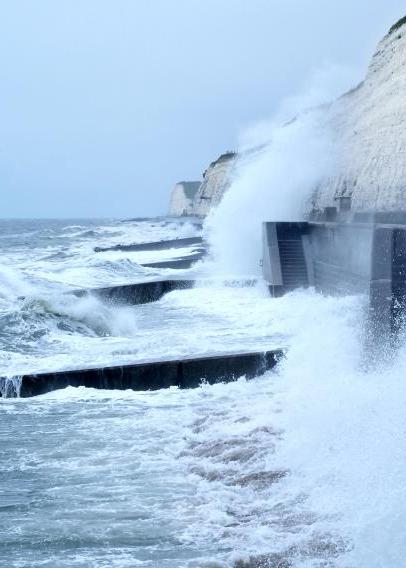 Sea spray and waves hitting coastal walkway